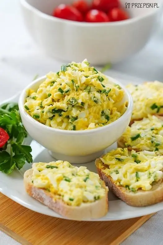 Panino gourmet tagliato a metà che mostra strati di avocado, salmone e rucola su pane ai cereali
