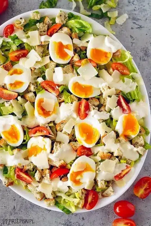 Dettaglio ravvicinato di insalata con scaglie di parmigiano e uova con tuorlo cremoso