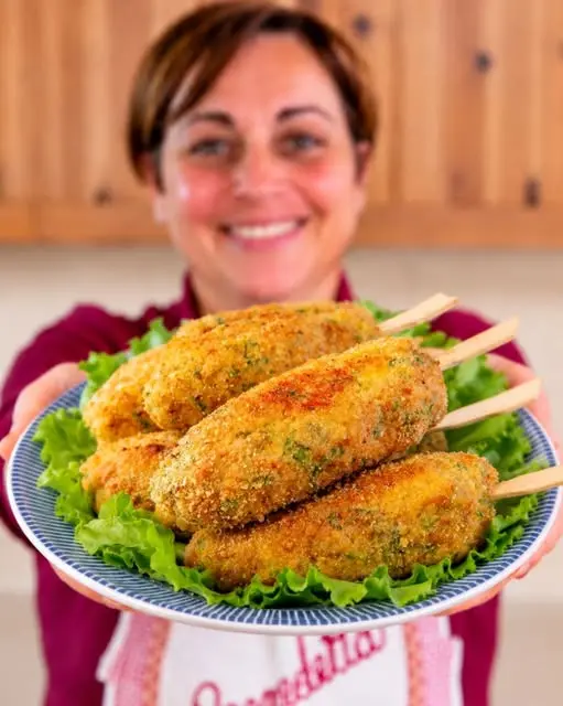 Piatto di polpette di pollo e zucchine servite con una salsa allo yogurt e spicchi di limone