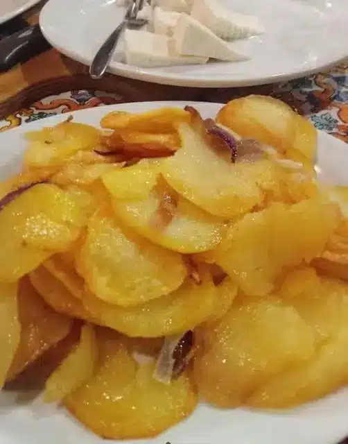 Patate al forno croccanti servite in una ciotola di ceramica con rametti di rosmarino fresco