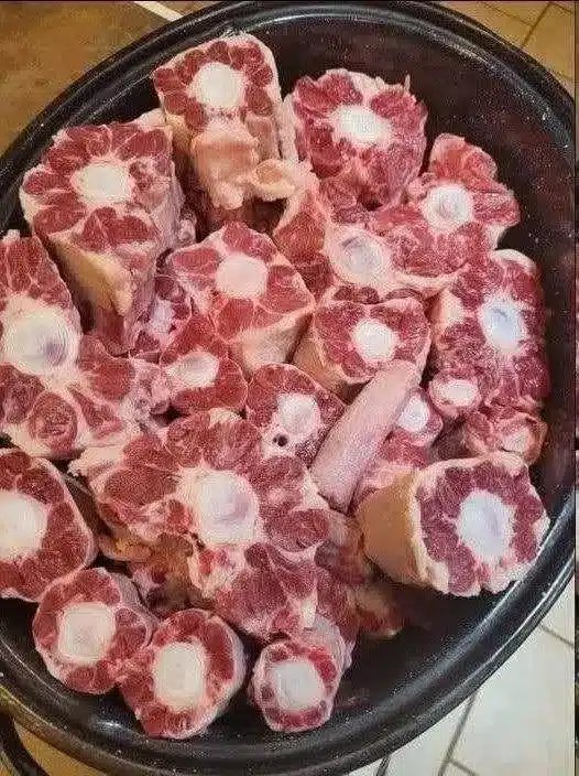 Coda di bue stufata servita in un piatto di ceramica con sugo denso al pomodoro
